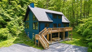 Een tweelaags huis met een terras en een trap die naar de tweede verdieping leidt.