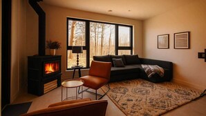 A living room with a fireplace, a sofa, a chair, and a rug.