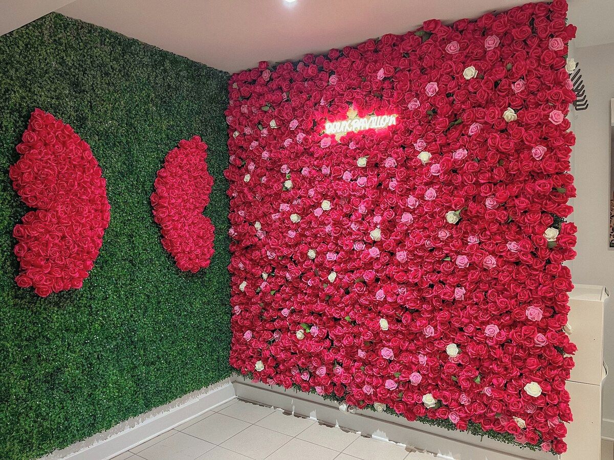 A room with a green wall and a large floral arrangement on the right.