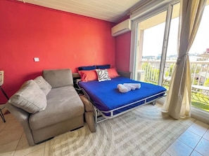 A room with a bed, a sofa, and a window with curtains. - Strada - Balcon, climatisation & privé (Villeurbanne)