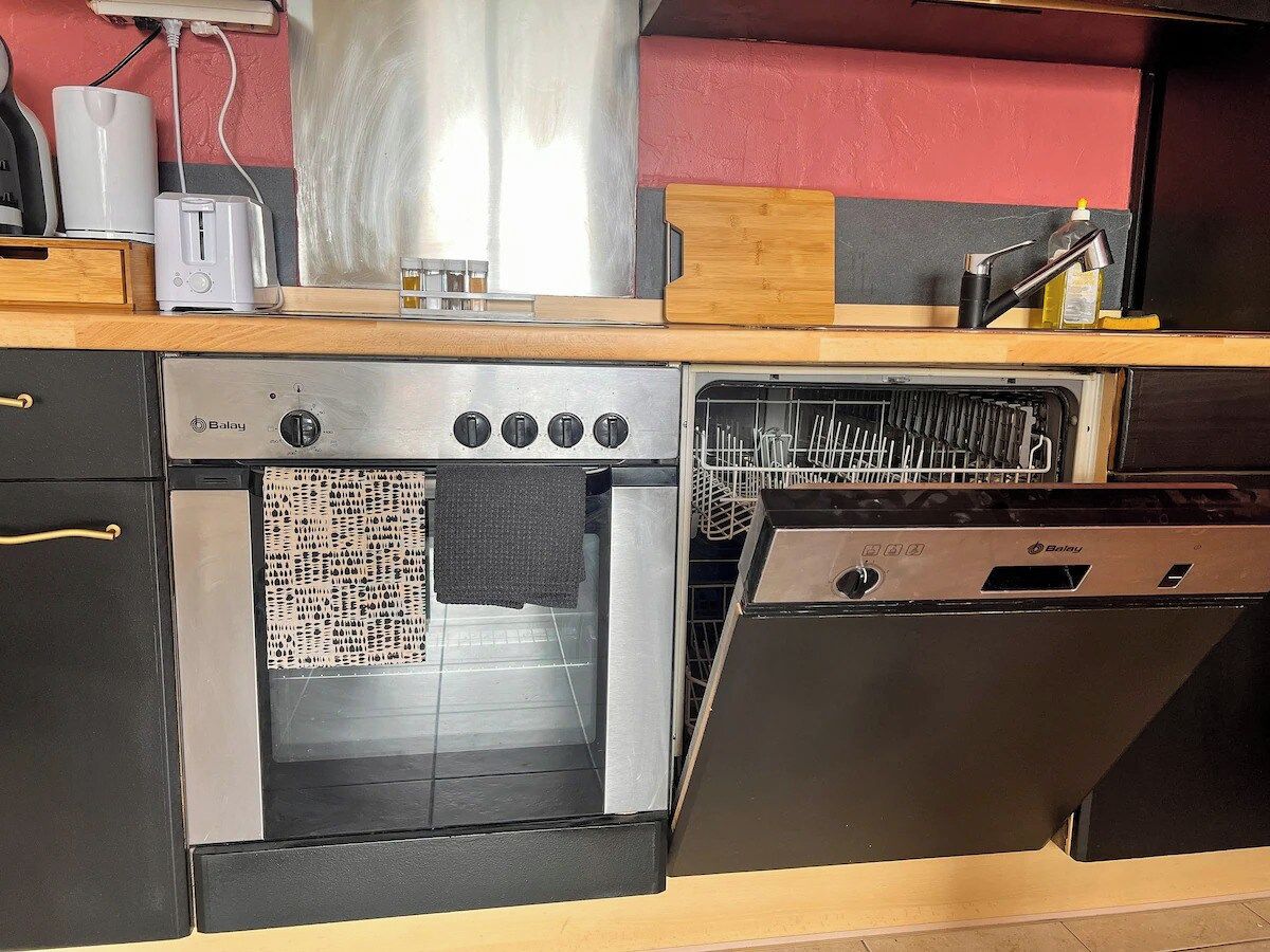 Una cocina con horno empotrado, lavavajillas y tostadora sobre la encimera.