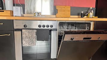 Una cocina con horno empotrado, lavavajillas y tostadora sobre la encimera.
