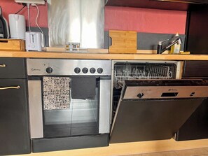 A kitchen with a built-in oven, a dishwasher, and a toaster on the countertop.