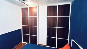Ein Zimmer mit einem Bett, blauer Wand und weißer Decke.