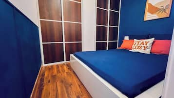 Un dormitorio con cama, armario y una obra de arte en la pared.