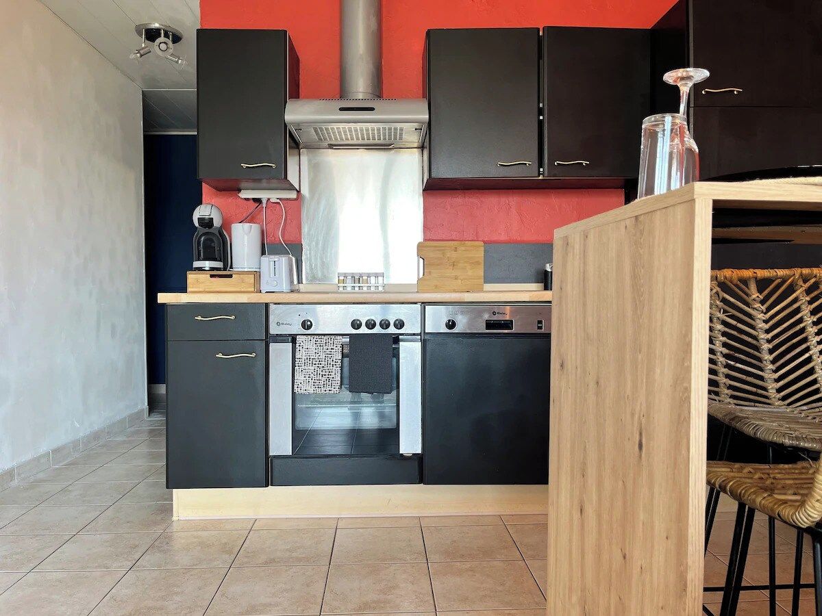 Eine kompakte Küche mit Einbauofen, Kaffeemaschine und Toaster.