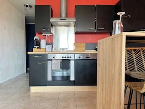 A compact kitchen with a built-in oven, a coffee maker, and a toaster.