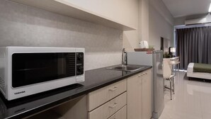 A compact kitchen with a microwave, sink, and refrigerator. - LKN Residence (Bangkok)