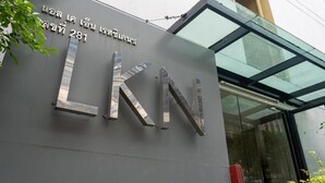A building entrance with a large metallic sign displaying 'LKN' and a number '281'. - LKN Residence (Bangkok)