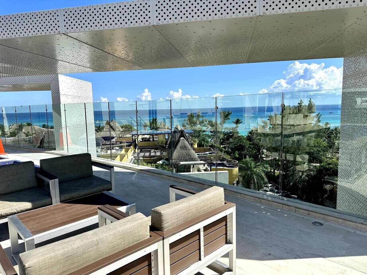 A rooftop terrace with seating and a view of the ocean.