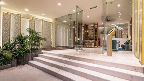 Un hall d’hôtel moderne avec un escalier menant à la réception.