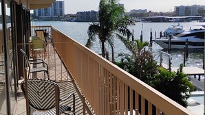 A balcony with a view of a marina, including boats and buildings in the background.