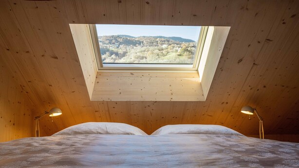 A bedroom with a skylight, a bed, and two bedside lamps. - Starry Loft 212 (Novale di Sotto)