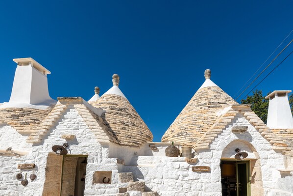 A traditional stone building with multiple conical roofs and a central entrance.
