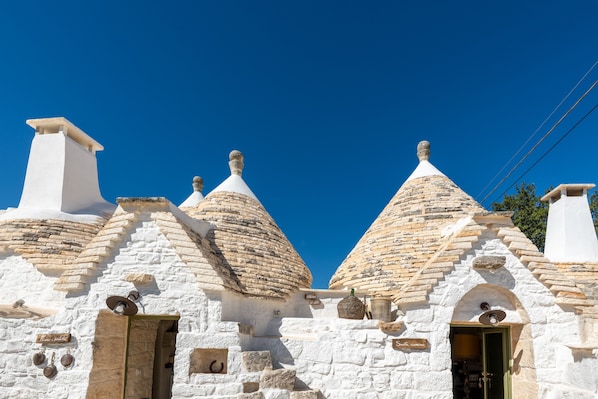 A traditional stone building with multiple conical roofs and a central entrance.