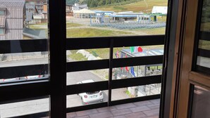 A view from a window with a view of a building complex, including a parking area and a flag display.
