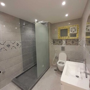 Ein modernes Badezimmer mit einer einteiligen Duschkabine, einer Toilette und einem Waschbecken.