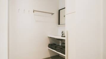 Une petite salle de bain fermée, avec un lavabo blanc, un miroir et un porte-serviettes.