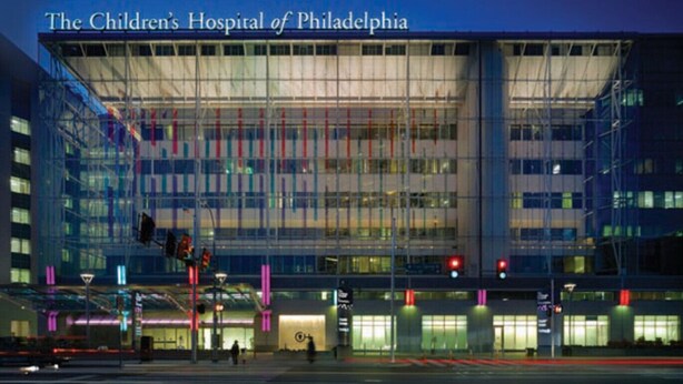 The Children's Hospital of Philadelphia with a modern glass facade and a clear blue sky in the background. - The Bella Vista Townhouse (Philadelphia)