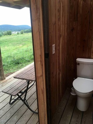 Une terrasse en bois avec des toilettes et une table.