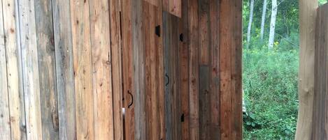 Una struttura in legno con panchina, tettoia e vista su spazi verdi.