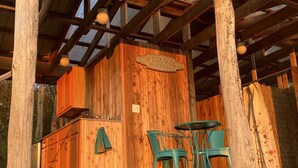 A rustic wooden structure with a 'Welcome to Our Farm' sign, a small kitchen area, and a seating arrangement with chairs. - Gorgeous Finger Lakes Accommodation near Ithaca for Glamping in New York (Brooktondale)