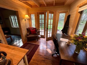 A cozy cabin interior with a wooden floor, a dining table, a sofa, and a chair. - Owl Creek Cabin Mountain Getaway near Ashland, Oregon (Ashland)