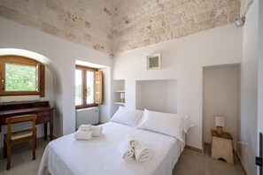 Une chambre à coucher avec un lit, un bureau, une chaise et une fenêtre.
