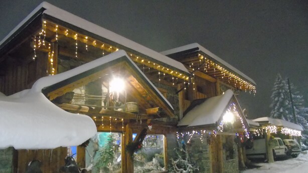 A snow-covered lodge with multiple windows and a wooden exterior. - Apartment in resort center chalet (Chamrousse)