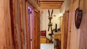 A wooden hallway with a tiled floor leading to a room with a bed and a dresser. - Apartment in resort center chalet (Chamrousse)