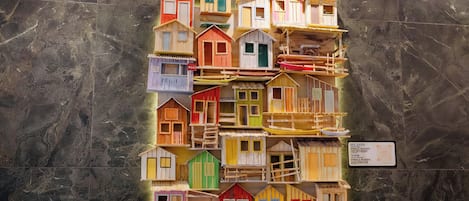 Un conjunto de coloridas casas de madera en miniatura expuestas sobre una pared de mármol.