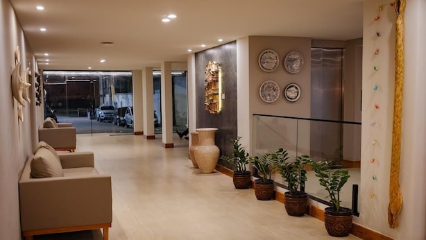 A modern lobby with a sofa, decorative vases, potted plants, and a glass railing. - Amazon Seasons Hotel (Belém)