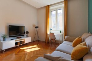 A modern living room with a sofa, TV, and a small table. - Della Corte House - Elegant Apart. Central Station (Milano)