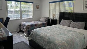 A bedroom with two beds, a ceiling fan, and a desk with a lamp. - Cozy 2 Bedroom 1 Bath Canal Front Home On Ramrod Key (Ramrod Key)