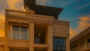 A two-story building with a symmetrical facade, large windows, and a central entrance with steps. - Coastal Echoes Inn (Kochi)