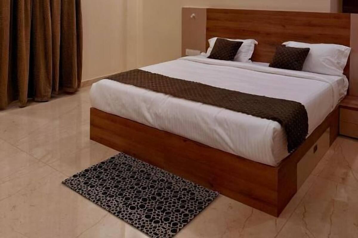 Ein modernes Hotelzimmer mit einem großen Bett, einem Deckenventilator, einem Bild an der Wand und Blick auf den Eiffelturm.
