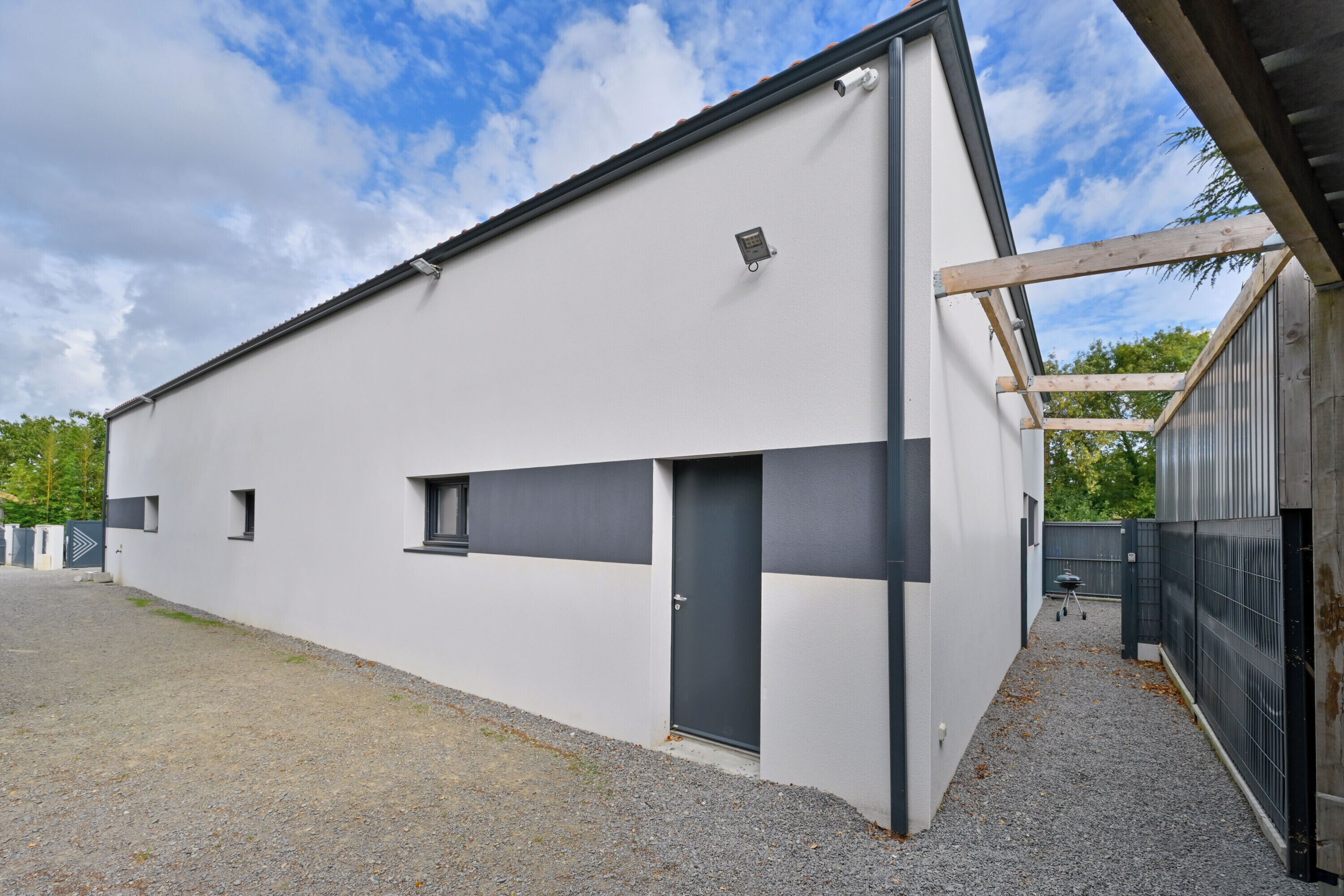 Un bâtiment moderne doté d’un toit plat, d’une porte et d’une petite fenêtre.
