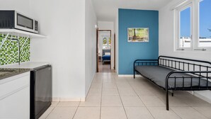 A compact room with a kitchenette, a bed, and a window. - Near the Water Shared Pool Pets Permitted (San Juan)