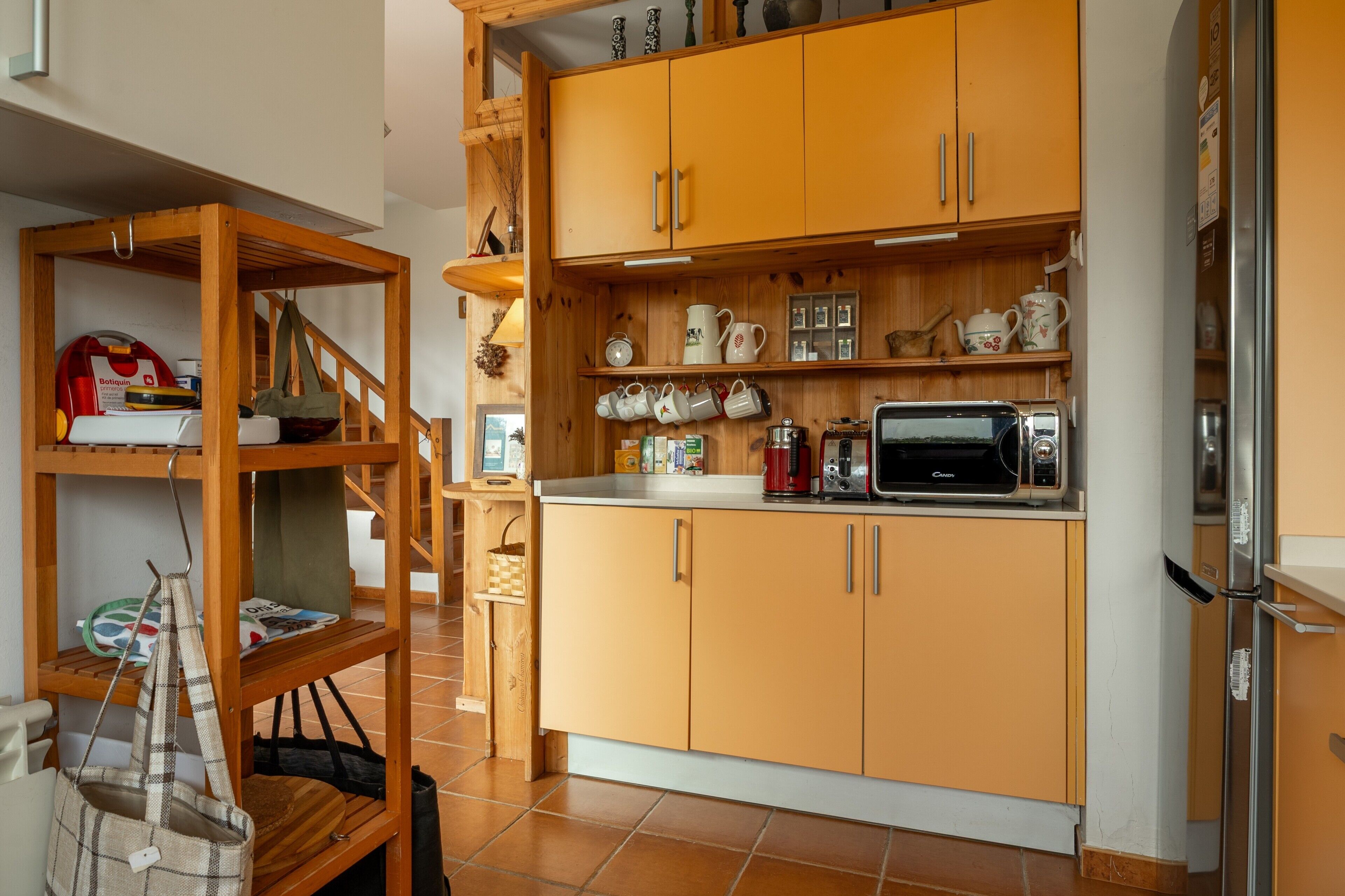 Una cocina con armarios de madera, microondas y cafetera.