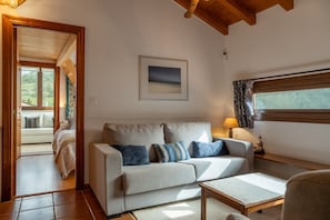 Un salon avec un canapé, une table basse, une lampe et un tableau encadré au mur.
