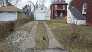 A residential area with a garage, a small shed, and a house with a porch. - House can sleep 8 or more people (Aliquippa)
