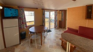 A compact living space with a kitchenette, a dining area, and a seating area. - Lovely home at park de Kniphorst (Anloo)