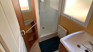 A compact bathroom with a shower, a sink, and a window. - Lovely home at park de Kniphorst (Anloo)