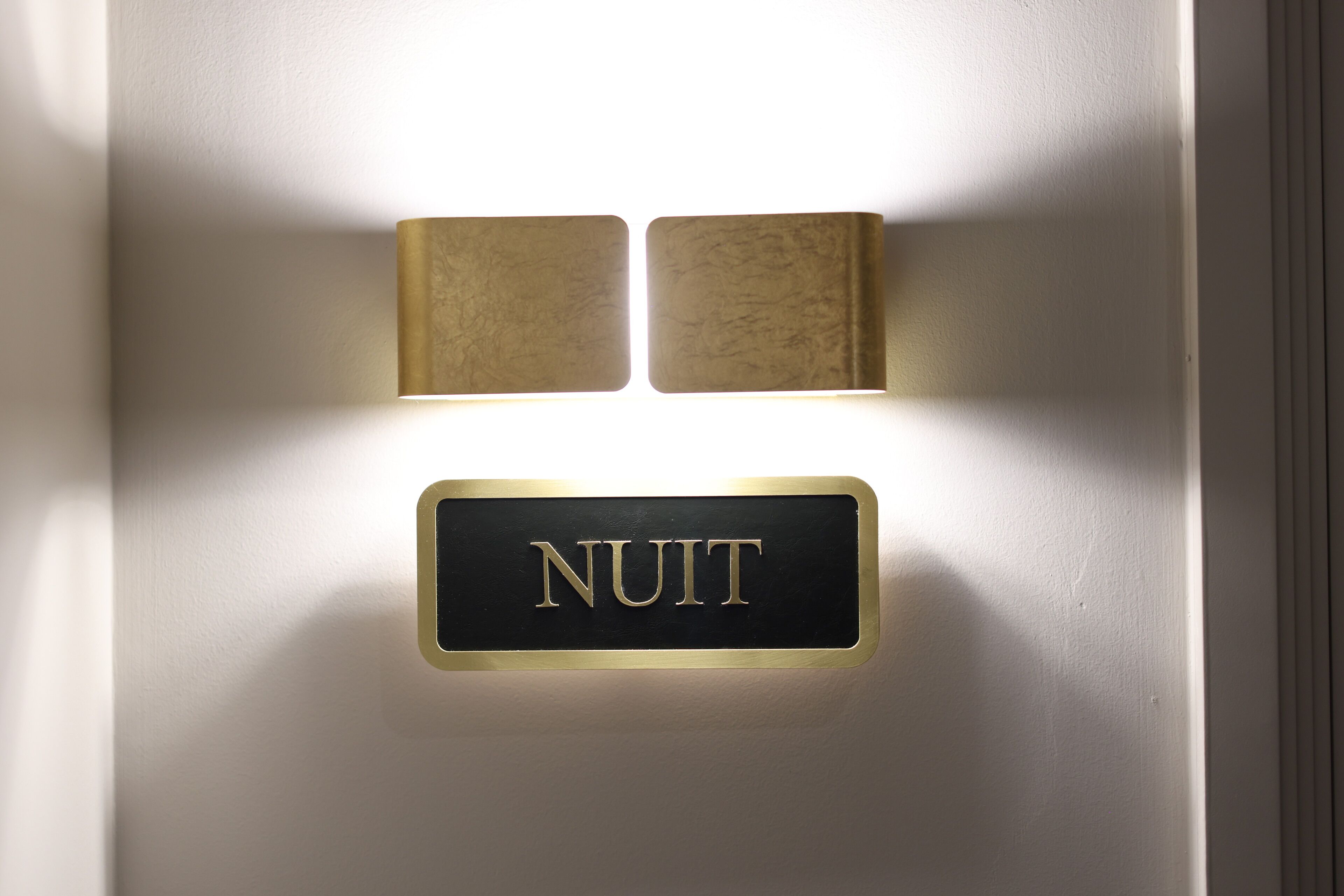 A wall-mounted sign with the word "NUIT" indicating the direction to the night area.