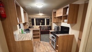 Una cucina compatta con mobili in legno, un fornello e un lavello.