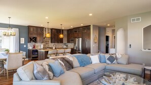 A modern kitchen with dark wood cabinets, stainless steel appliances, and pendant lighting.