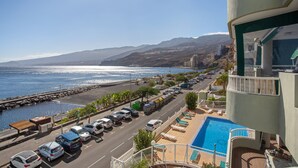 A coastal hotel with a pool, a parking lot, and a view of the sea and mountains. - Vacation Apartment 'Paraíso Atlántico' with Sea View, Wi-Fi & Air Conditioning (Radazul)