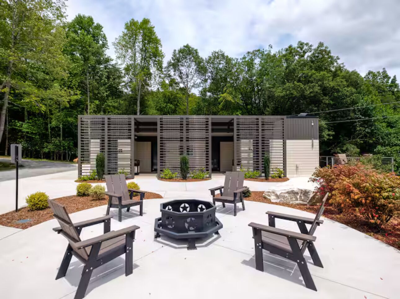 An outdoor seating area with four chairs and a central fire pit.