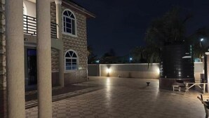 Un bâtiment en pierre doté d’un sol à carreaux et d’une grande citerne d’eau.