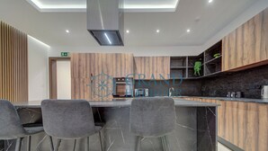Una cocina moderna con una isla central, taburetes de bar y armarios de madera.